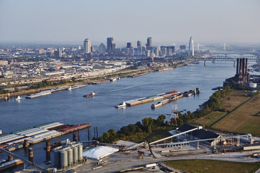 Photo of barges, bridges and other freight assets along the Mississippi River with St. Louis skyline in background