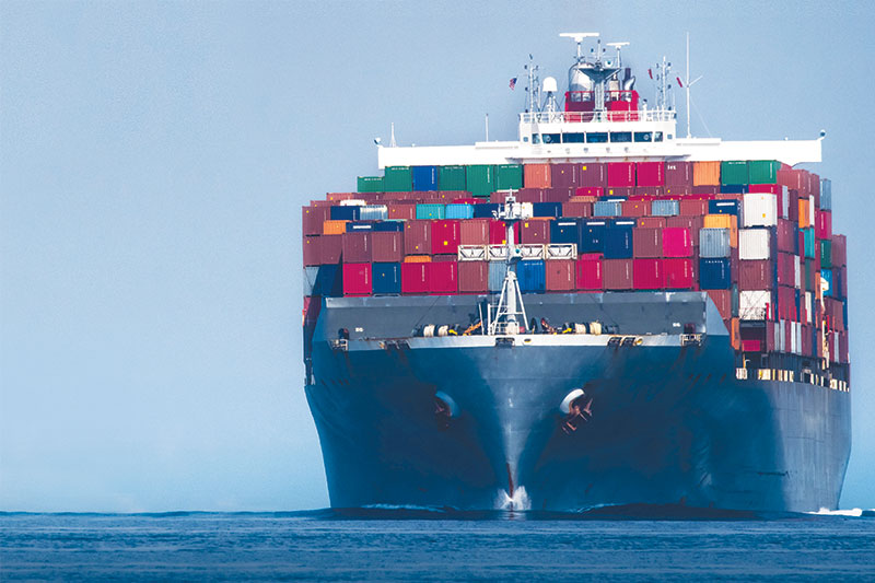 Image of a boat on the ocean with containers stored on the front of the ship.