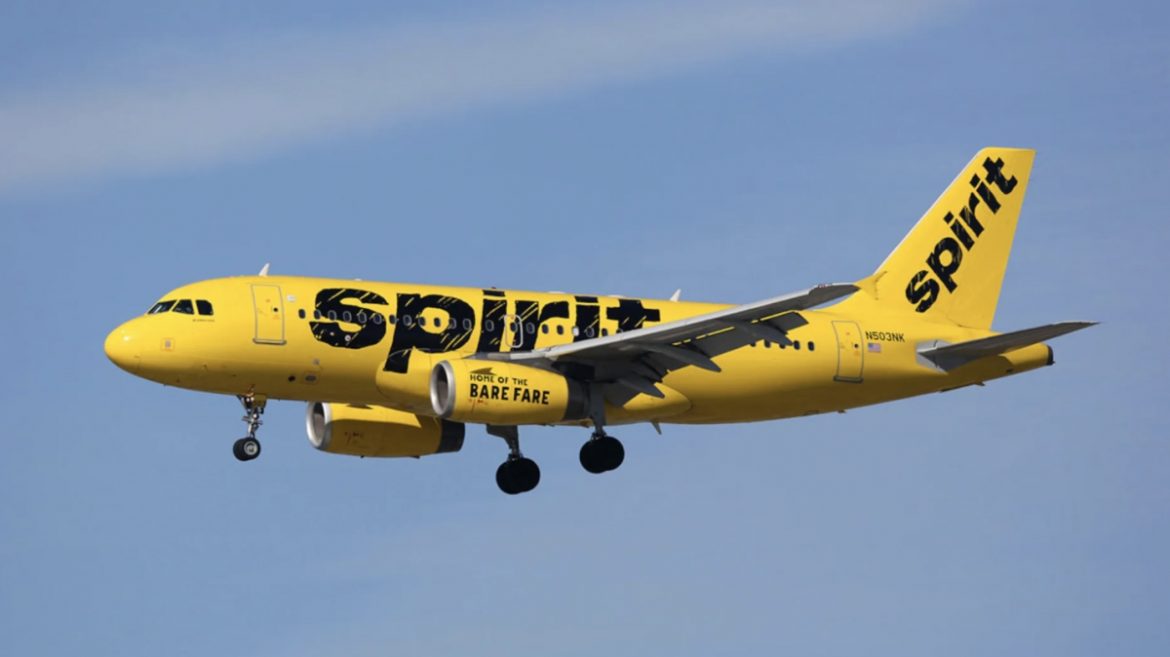 Image of a Spirit Airlines yellow plane flying in the air