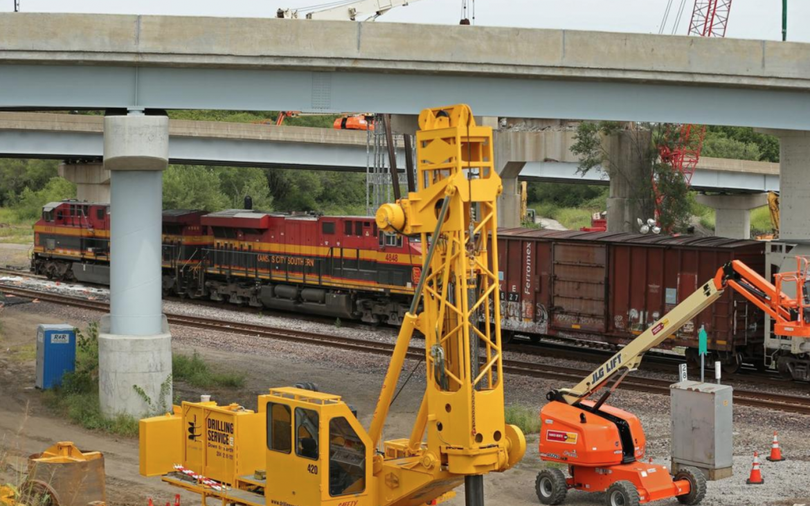 A Kansas City Southern freight train moves across tracks beneath feeder ramps to the Martin Luther King Bridge and past construction equipment on Thursday, Aug. 29, 2019, in East St. Louis. The Illinois Department of Transportation announced the bridge will remain closed until next summer at the earliest because extra freight traffic pushed through the region has slowed their ability to work at pace. Photo by Christian Gooden, cgooden@post-dispatch.com