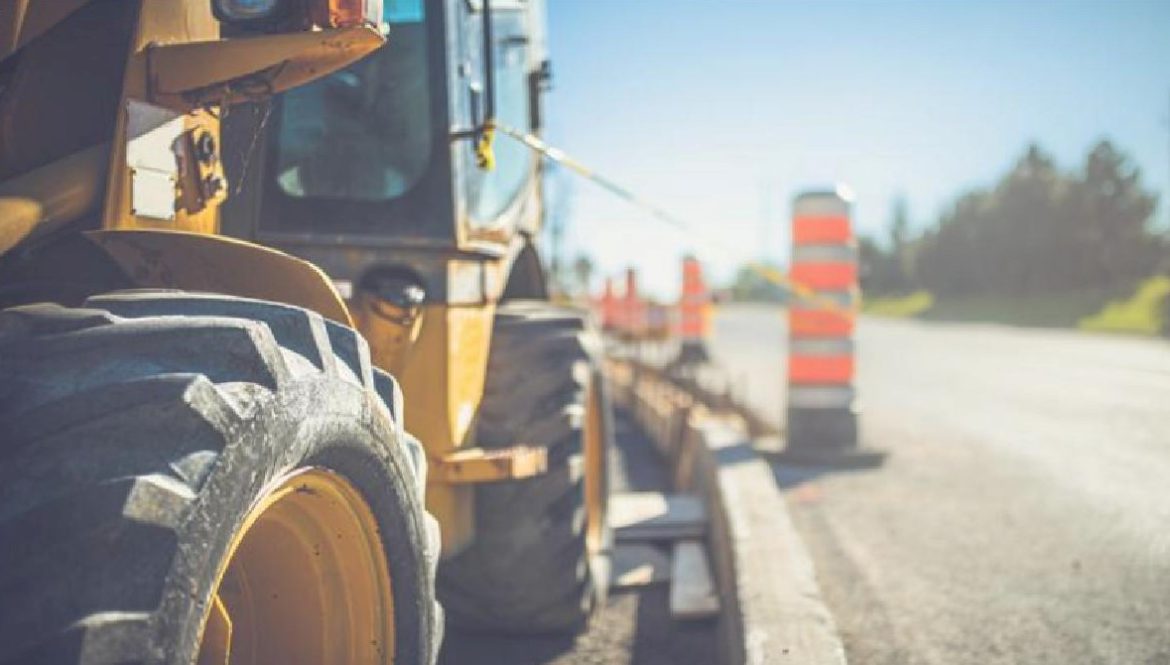 More than 2,000 new transportation projects began in Missouri and Illinois in the first year after a major federal infrastructure funding bill, according to an industry group study. Photo of a tractor and road work cones.