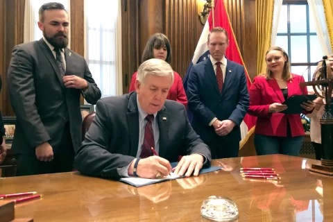 Image of Governor Parson signing a document.