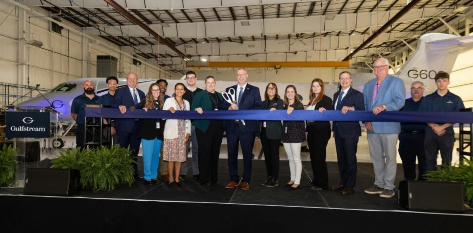 Photo of ribbon cutting at Gulfstream with 16 people in front of a jet