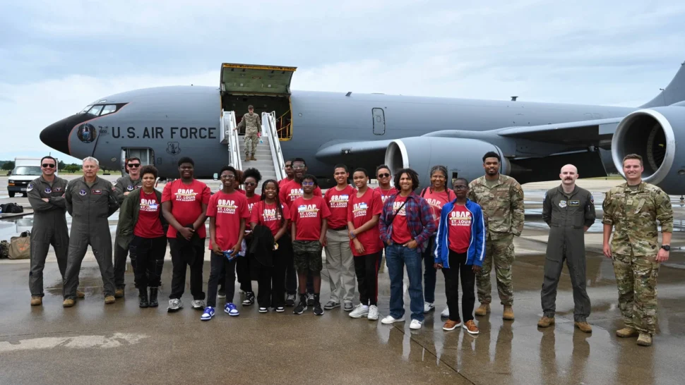 A St. Louis ACE Academy tour group poses in front of a large US Air Force plane, flanked by USAF Servicemen